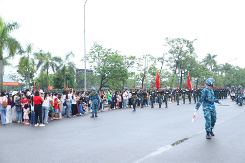 Người dân đội mưa cổ vũ buổi hợp luyện diễu binh kỷ niệm 80 năm Quốc khánh. (Ảnh: Quỳnh Nga)